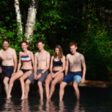 The whole fam jam on a log in lower Liard pool
